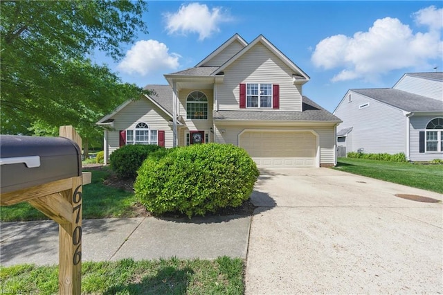traditional-style house featuring concrete driveway and an attached garage