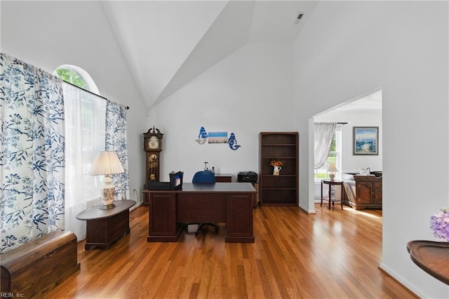 office featuring light wood-type flooring and high vaulted ceiling