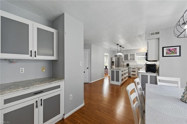 dining area featuring dark wood-type flooring and baseboards