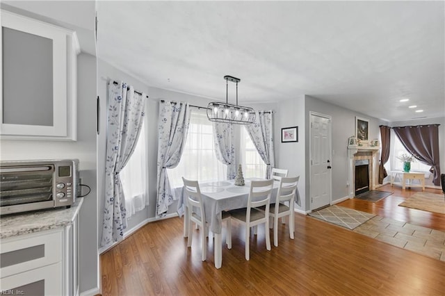 dining room with plenty of natural light, a chandelier, baseboards, light wood-type flooring, and recessed lighting