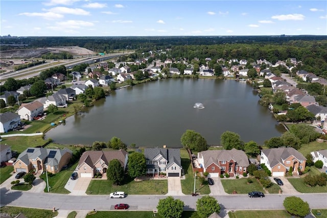 aerial view of property and surrounding area featuring nearby suburban area and a nearby body of water