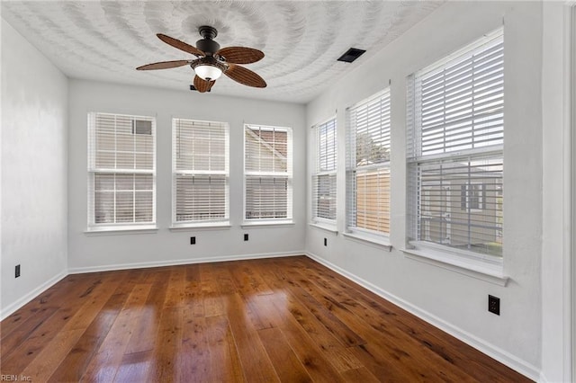 unfurnished sunroom featuring hardwood / wood-style floors and baseboards