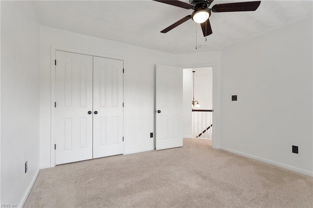 unfurnished bedroom featuring carpet floors, baseboards, a closet, and ceiling fan