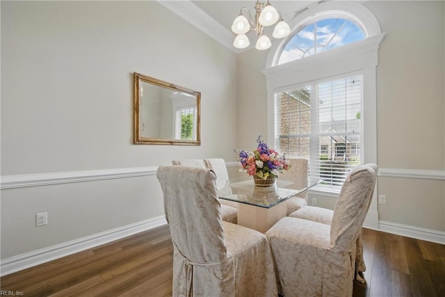 dining space with wood finished floors, a chandelier, plenty of natural light, baseboards, and ornamental molding