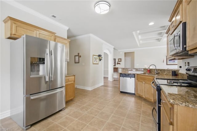 kitchen featuring appliances with stainless steel finishes, a peninsula, a sink, light stone counters, and ornamental molding