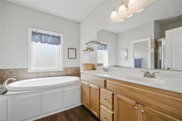full bath with a bath, double vanity, and a stall shower