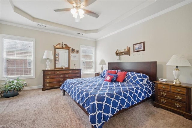 carpeted bedroom featuring a raised ceiling, ornamental molding, and ceiling fan