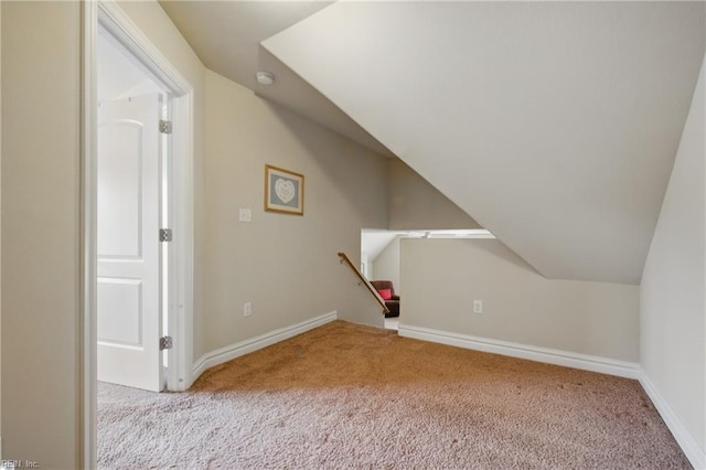 additional living space featuring carpet, vaulted ceiling, and baseboards