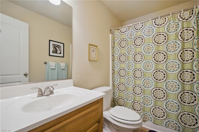 bathroom featuring toilet, vanity, and a shower with shower curtain