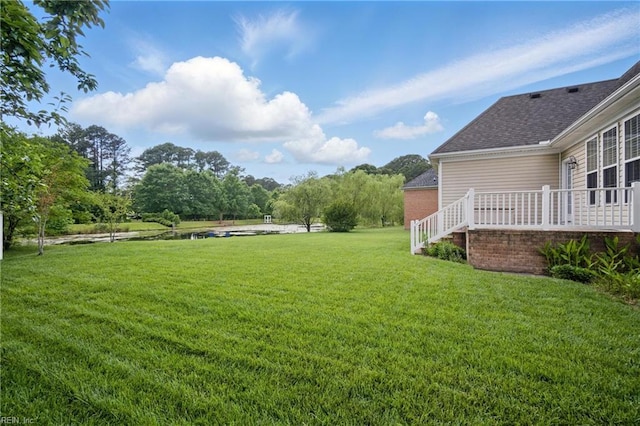 view of green lawn with a water view
