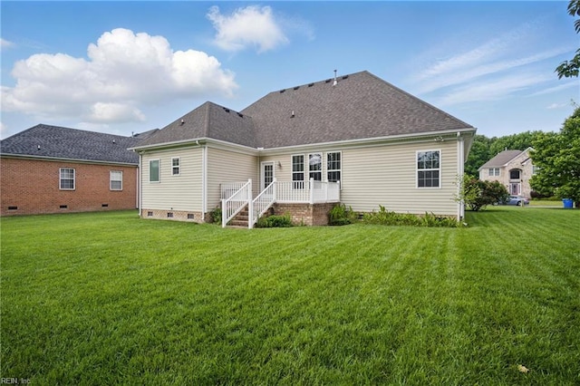 rear view of house with crawl space, a lawn, and a shingled roof