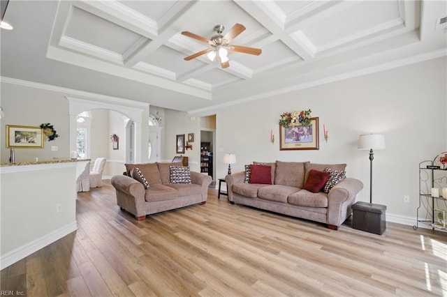 living area with ceiling fan, arched walkways, light wood-style floors, coffered ceiling, and beamed ceiling
