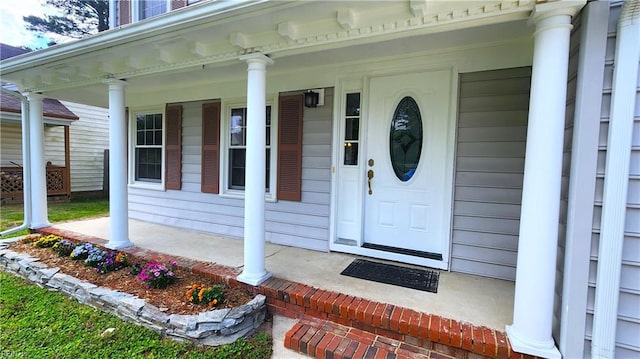 view of exterior entry featuring covered porch