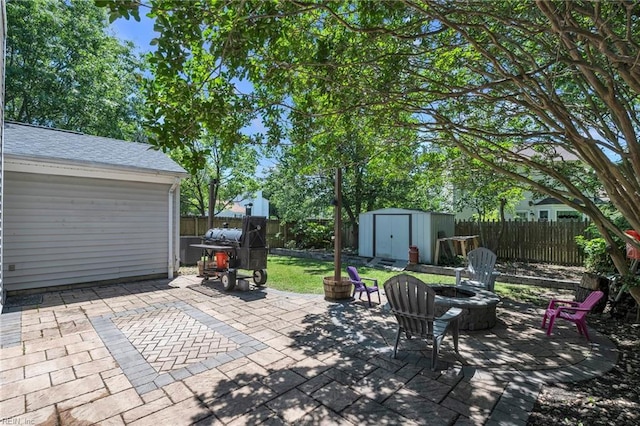 view of patio / terrace featuring a shed, a fire pit, a fenced backyard, and grilling area