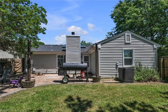 back of house featuring central air condition unit, a patio, and a chimney