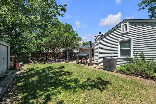 view of yard featuring central AC unit and a shed