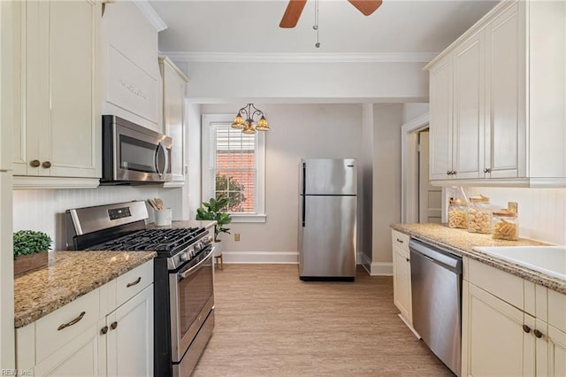 kitchen with appliances with stainless steel finishes, baseboards, light wood-type flooring, ceiling fan, and ornamental molding