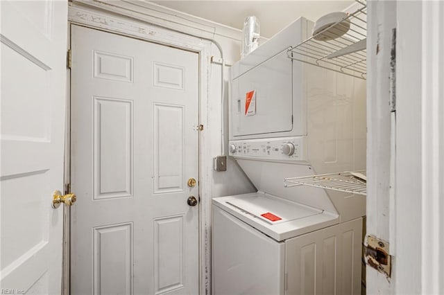 laundry room featuring stacked washer / drying machine