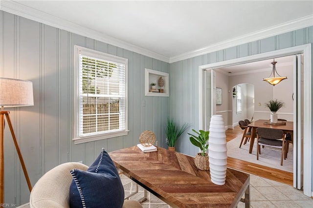 dining space with ornamental molding, arched walkways, light tile patterned flooring, and baseboards
