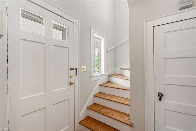 entrance foyer featuring stairway and baseboards