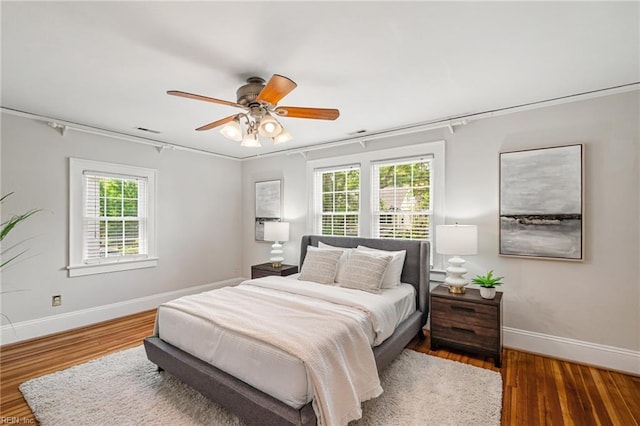 bedroom with baseboards, wood finished floors, and ceiling fan