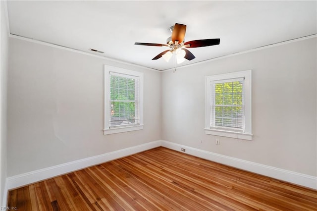 unfurnished room with baseboards, plenty of natural light, light wood-style flooring, crown molding, and a ceiling fan