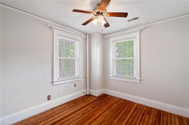 unfurnished room with baseboards, wood finished floors, and plenty of natural light