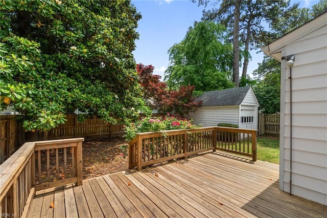 wooden deck featuring a fenced backyard and an outbuilding
