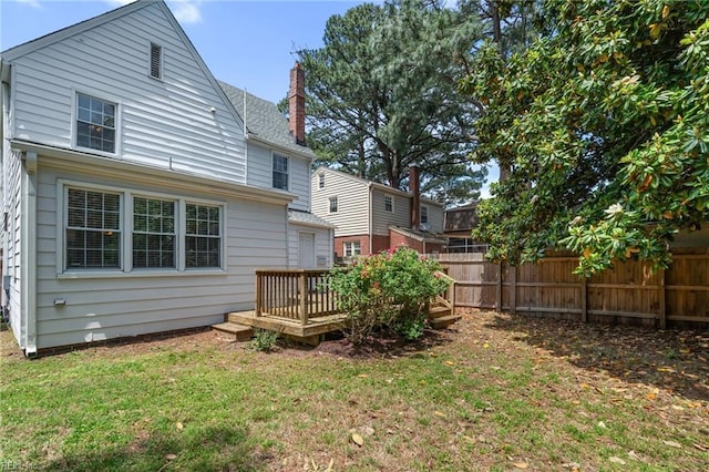 back of house with a wooden deck and a chimney