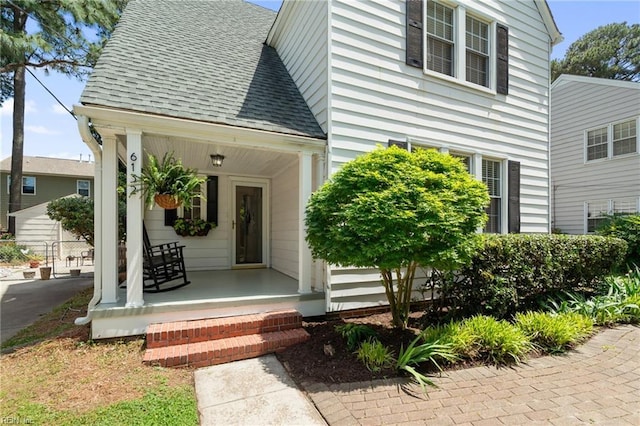 view of front of house with covered porch and a shingled roof