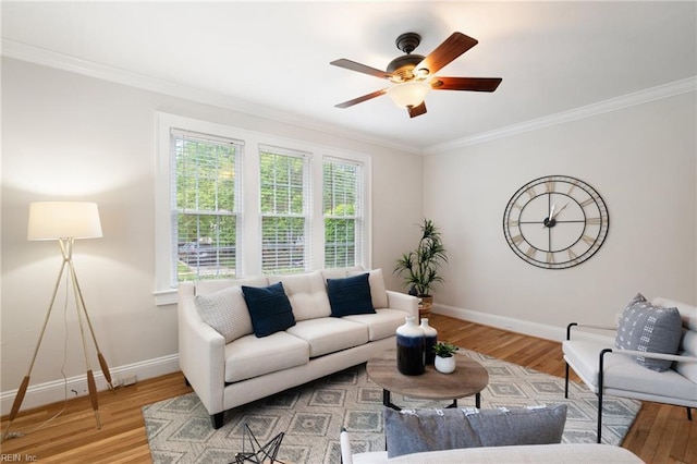 living area with ornamental molding, baseboards, a ceiling fan, and wood finished floors