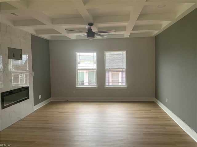 unfurnished living room featuring coffered ceiling, light wood-style flooring, ceiling fan, beamed ceiling, and baseboards