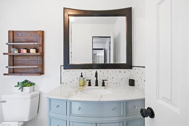 bathroom featuring backsplash, vanity, and toilet