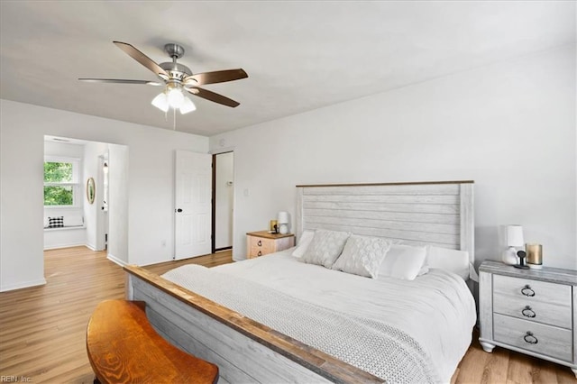 bedroom with light wood finished floors, ceiling fan, and baseboards