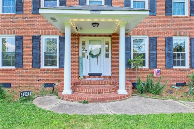 view of exterior entry featuring brick siding