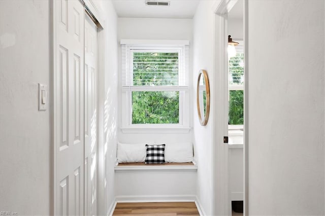 doorway with wood finished floors and baseboards