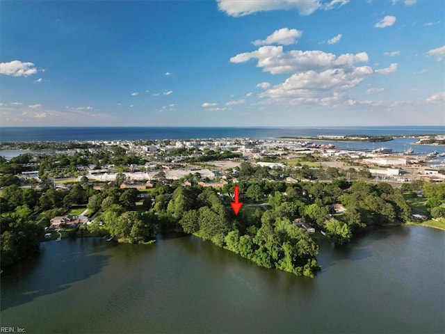 view of property location featuring a nearby body of water and a tree filled landscape