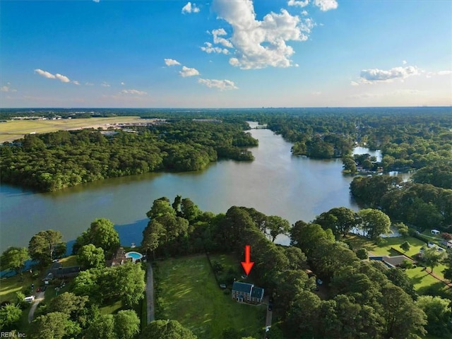 aerial view of property's location with a nearby body of water and a forest