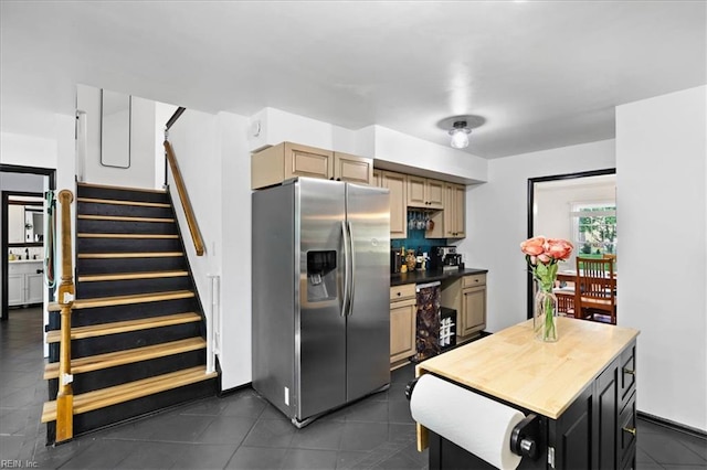 kitchen featuring stainless steel refrigerator with ice dispenser and dark tile patterned floors