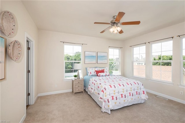 bedroom with light colored carpet, baseboards, and ceiling fan