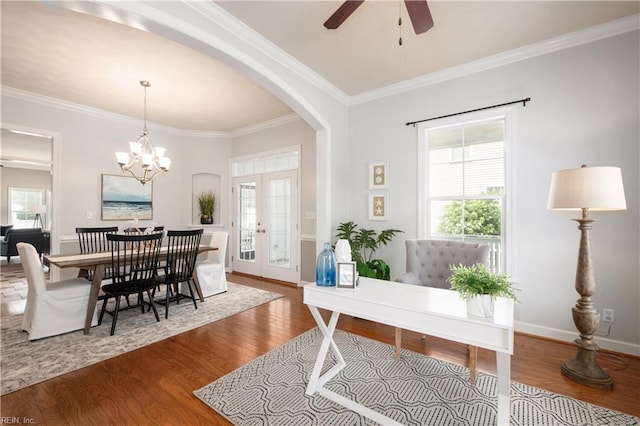 foyer entrance with arched walkways, wood finished floors, ceiling fan, ornamental molding, and french doors