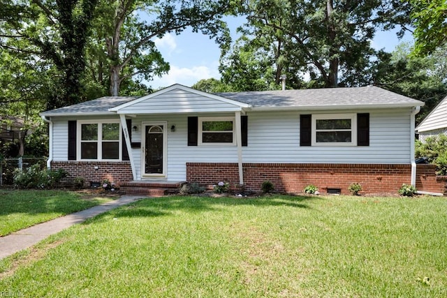 view of front of home with brick siding, a front lawn, and a shingled roof