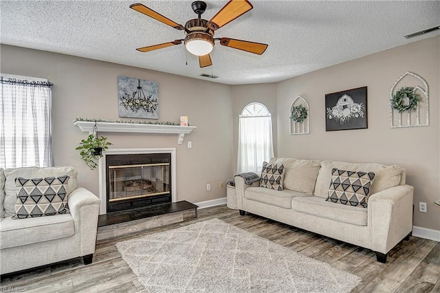5120 Bardith Cir, Virginia Beach, VA 23455 - living area with wood finished floors, a ceiling fan, a glass covered fireplace, a textured ceiling, and baseboards