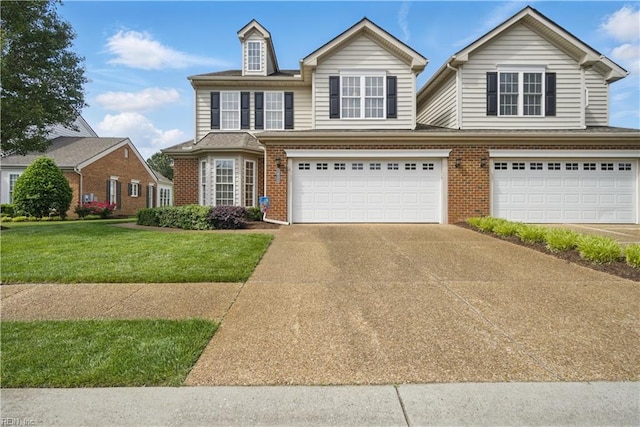 traditional-style house featuring a garage, brick siding, driveway, and a front yard