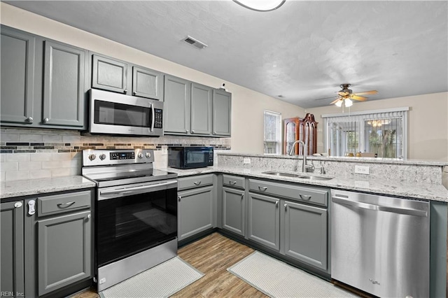 1309 W 25th St, Norfolk, VA 23508 - kitchen featuring stainless steel appliances, a sink, gray cabinets, and a peninsula