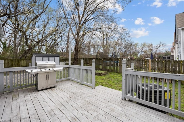 1309 W 25th St, Norfolk, VA 23508 - deck featuring grilling area, a fenced backyard, a storage unit, and an outbuilding