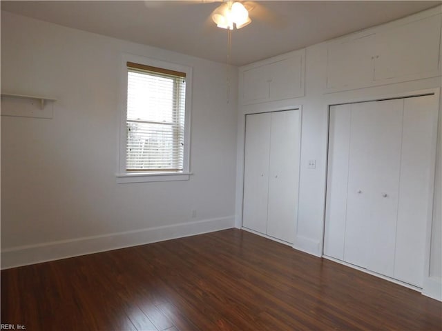 unfurnished bedroom with dark wood-type flooring and baseboards