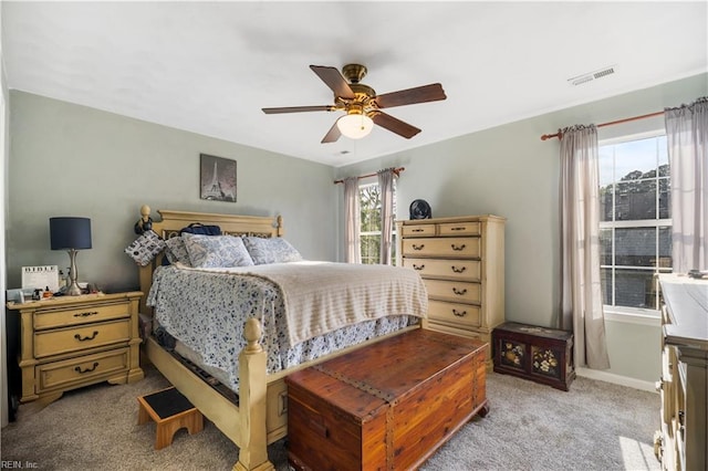 bedroom featuring light carpet, a ceiling fan, and baseboards
