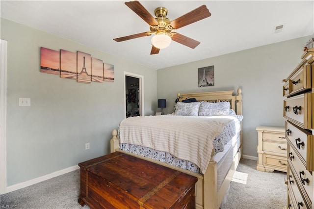 bedroom featuring light colored carpet, baseboards, and a ceiling fan