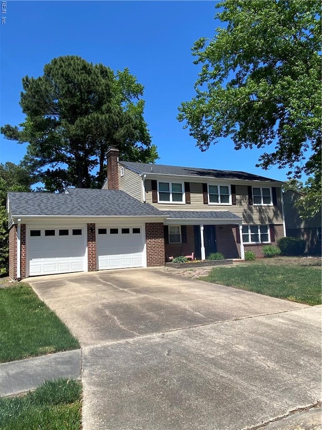 traditional-style house featuring driveway, an attached garage, brick siding, a chimney, and a front yard
